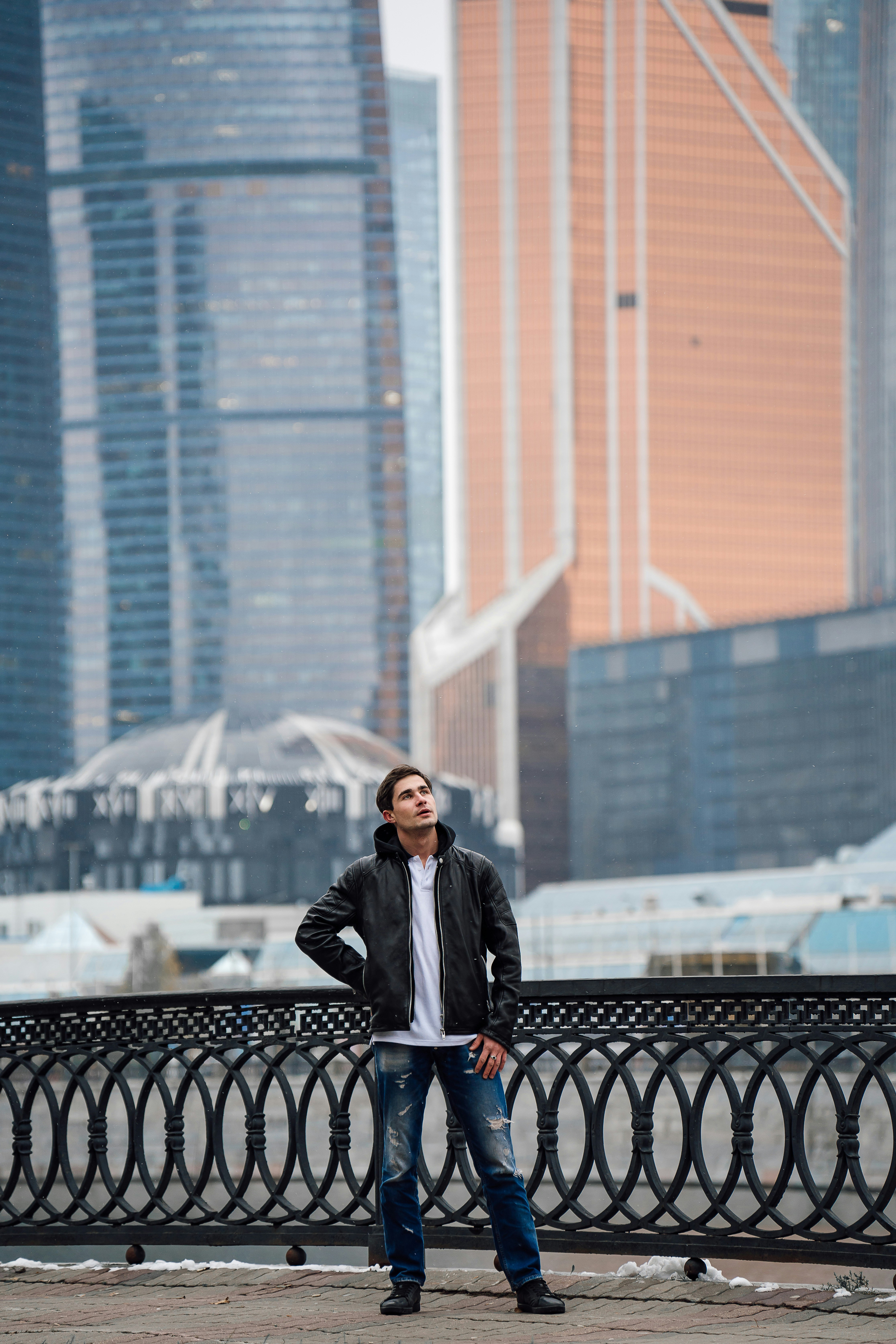 a man standing in front of a fence with his hands on his hips
