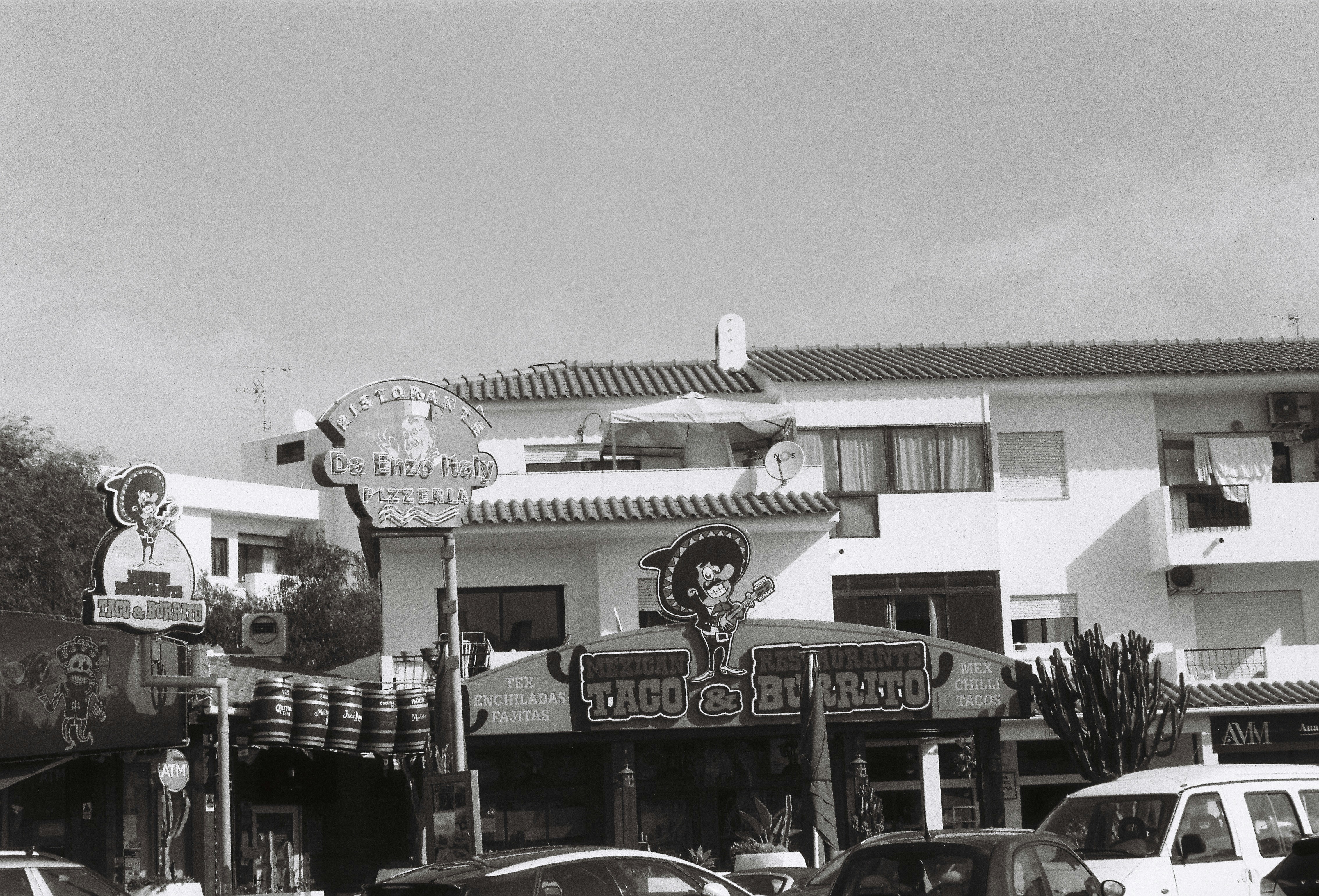 a black and white photo of cars parked in front of a building