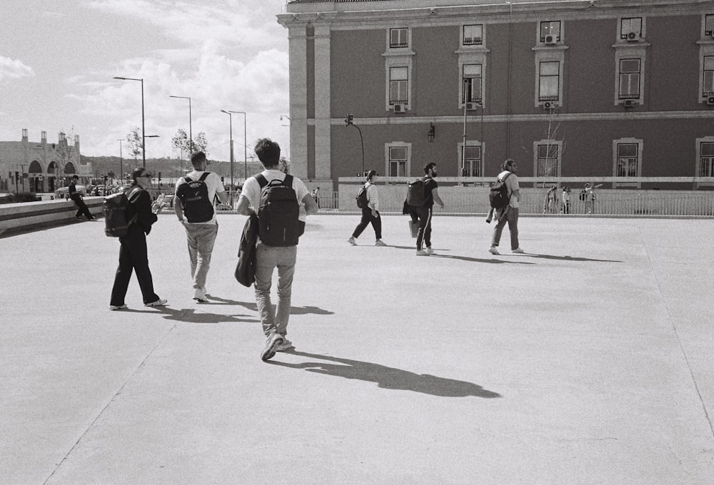 a group of people walking across a parking lot