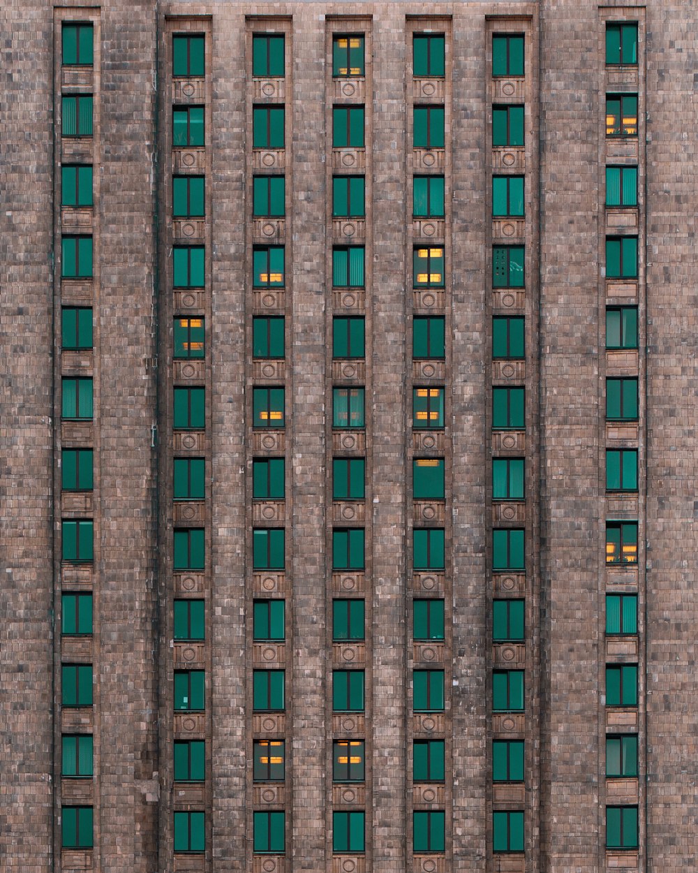 a very tall brick building with green windows