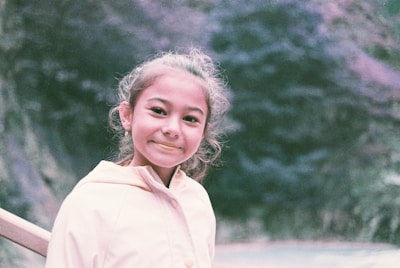 A caring mentor and a young girl sharing a smile during an outdoor activity.