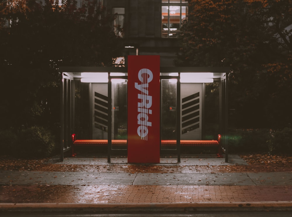 a bus stop with a red sign on it