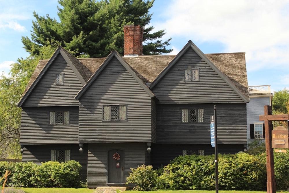 a large black house with a clock on the front of it