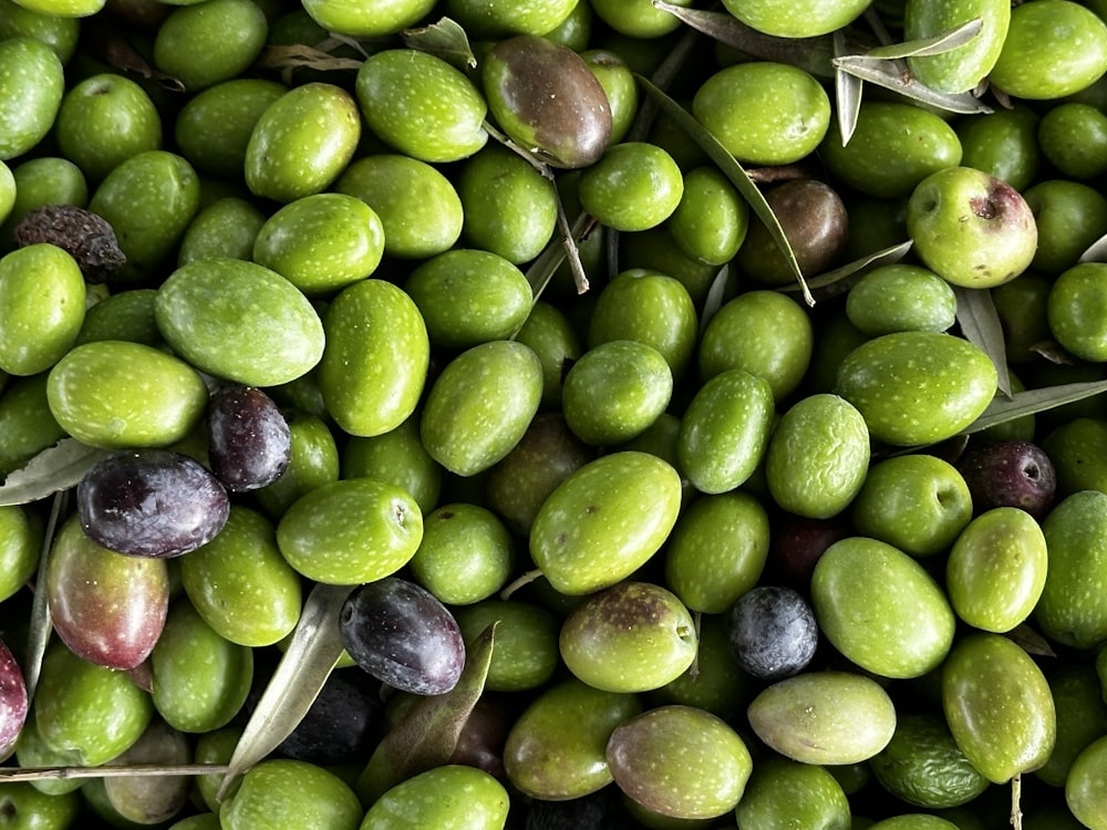 a pile of green olives and olives next to each other