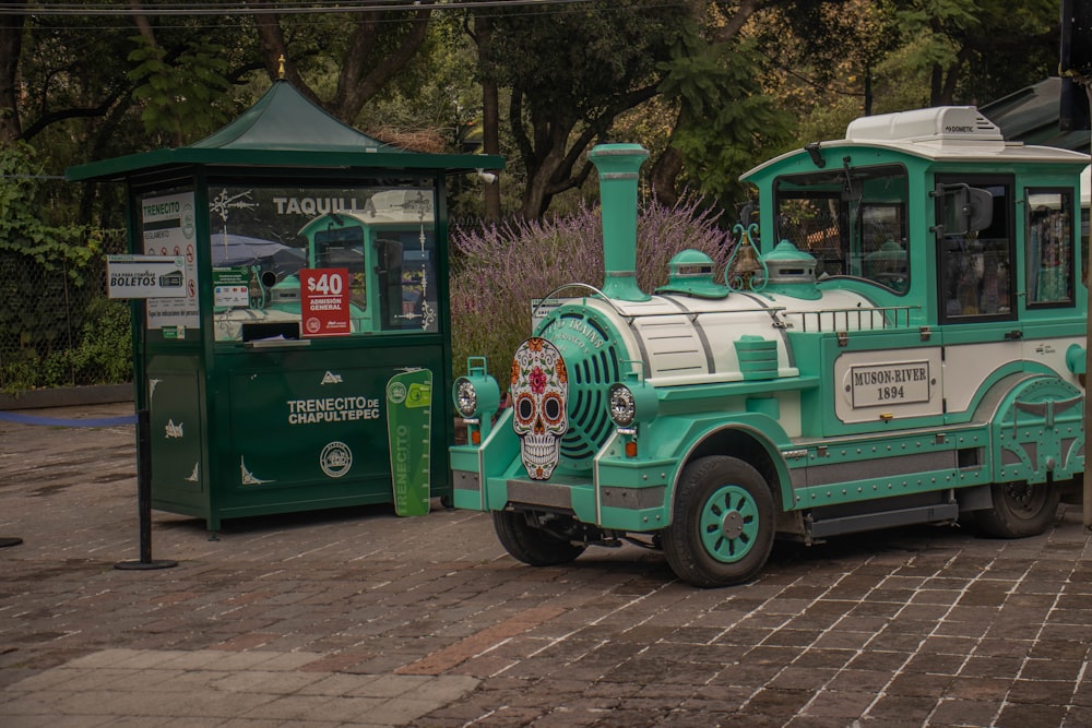 Un tren verde y blanco en un camino de baldosas