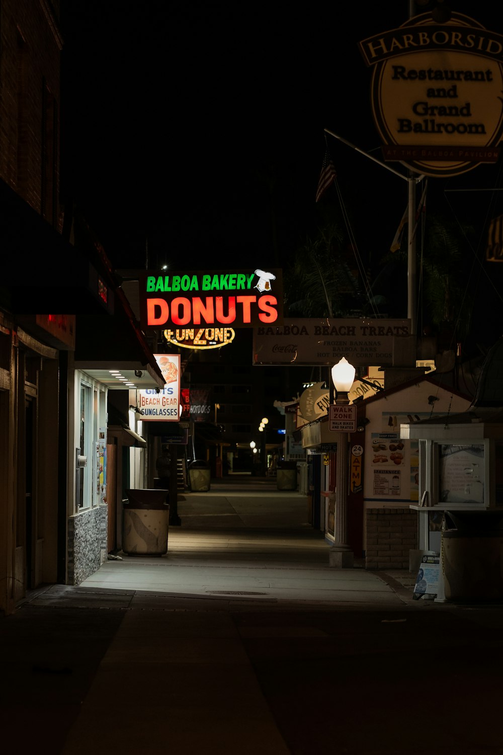 a dark alley way with a neon donuts sign