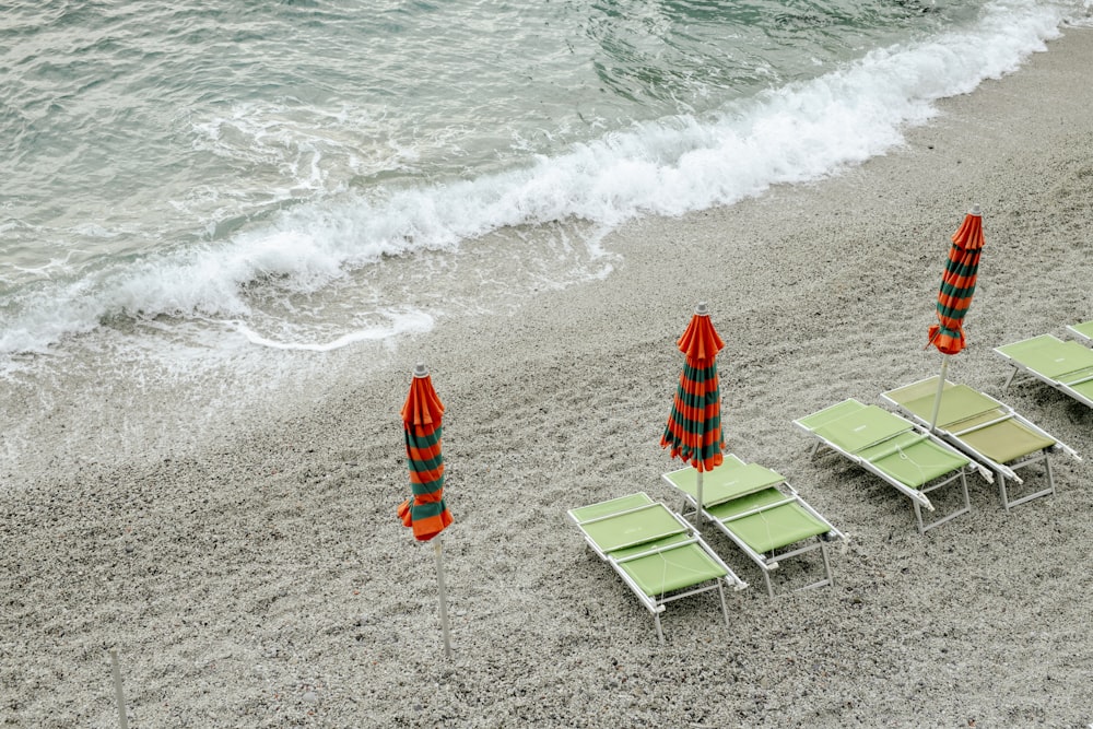 a beach with lawn chairs and umbrellas on the sand