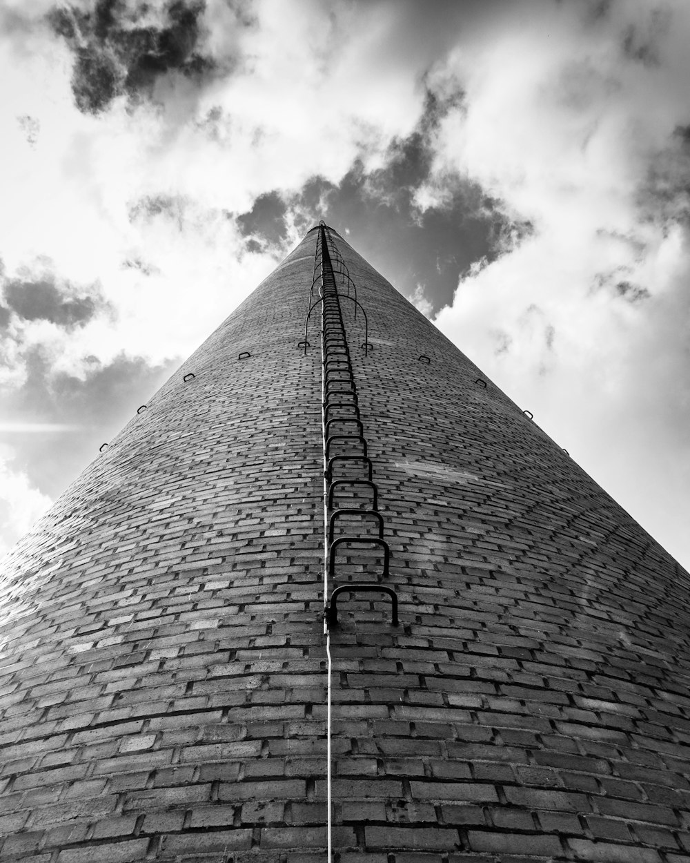 a black and white photo of a tall brick building