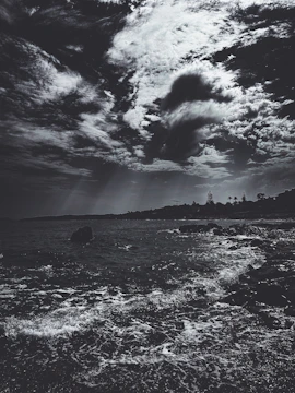 Storm clouds gathering above a windswept rocky coastline.