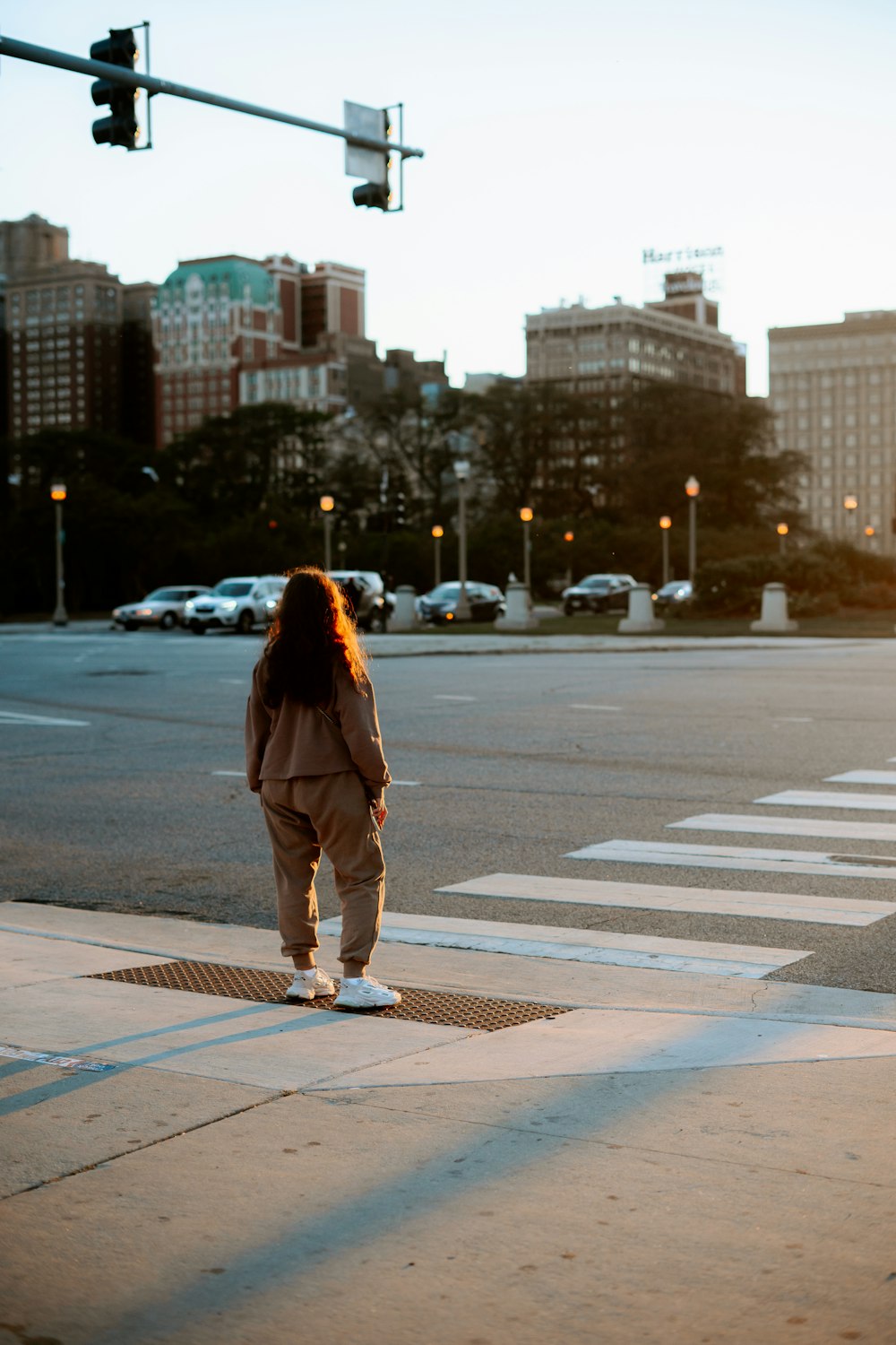 a person standing on a street corner with a traffic light in the background