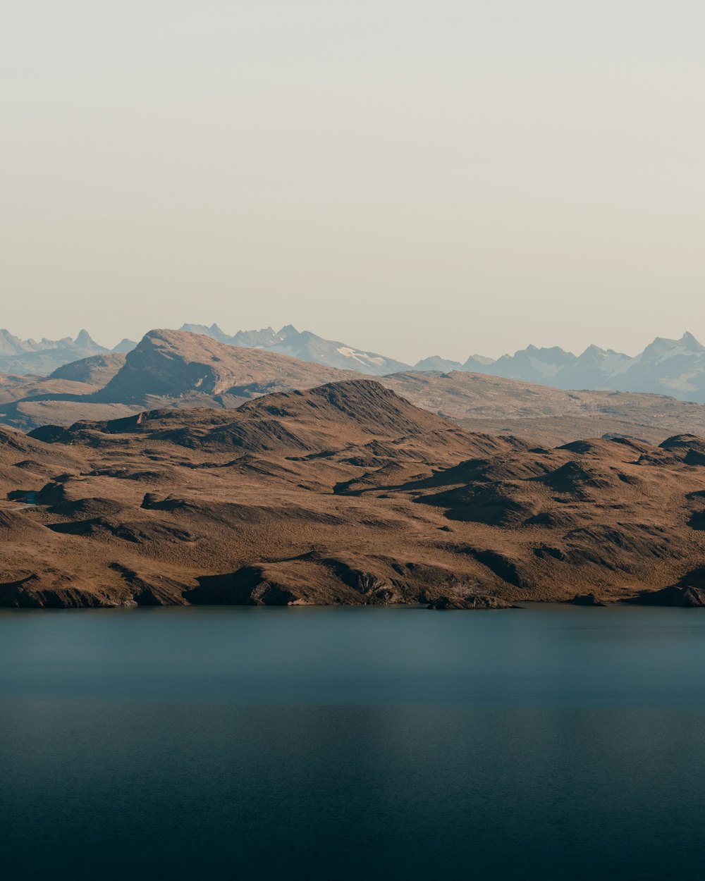 a mountain range with a body of water in the foreground