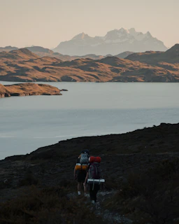A veteran family hiking a scenic mountain trail with backpacks and smiles