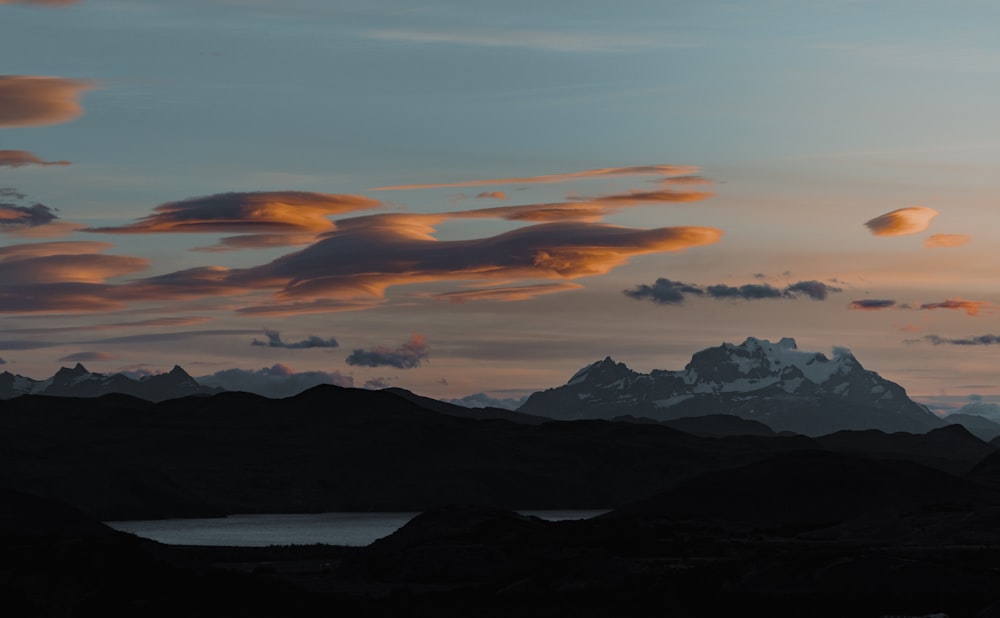 the sun is setting over a mountain range