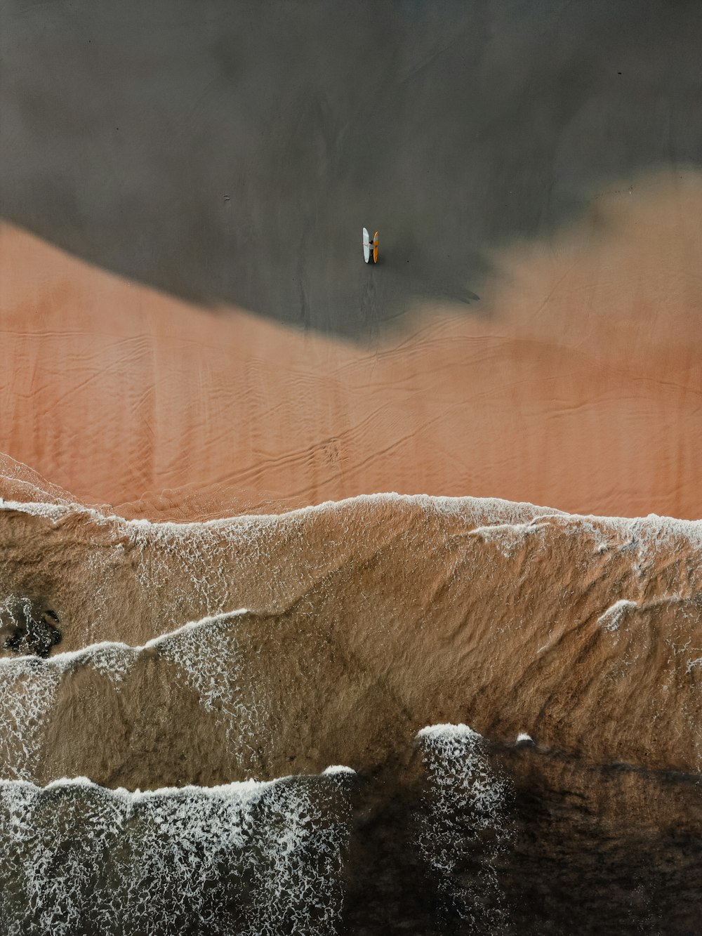 a person standing on top of a sandy beach