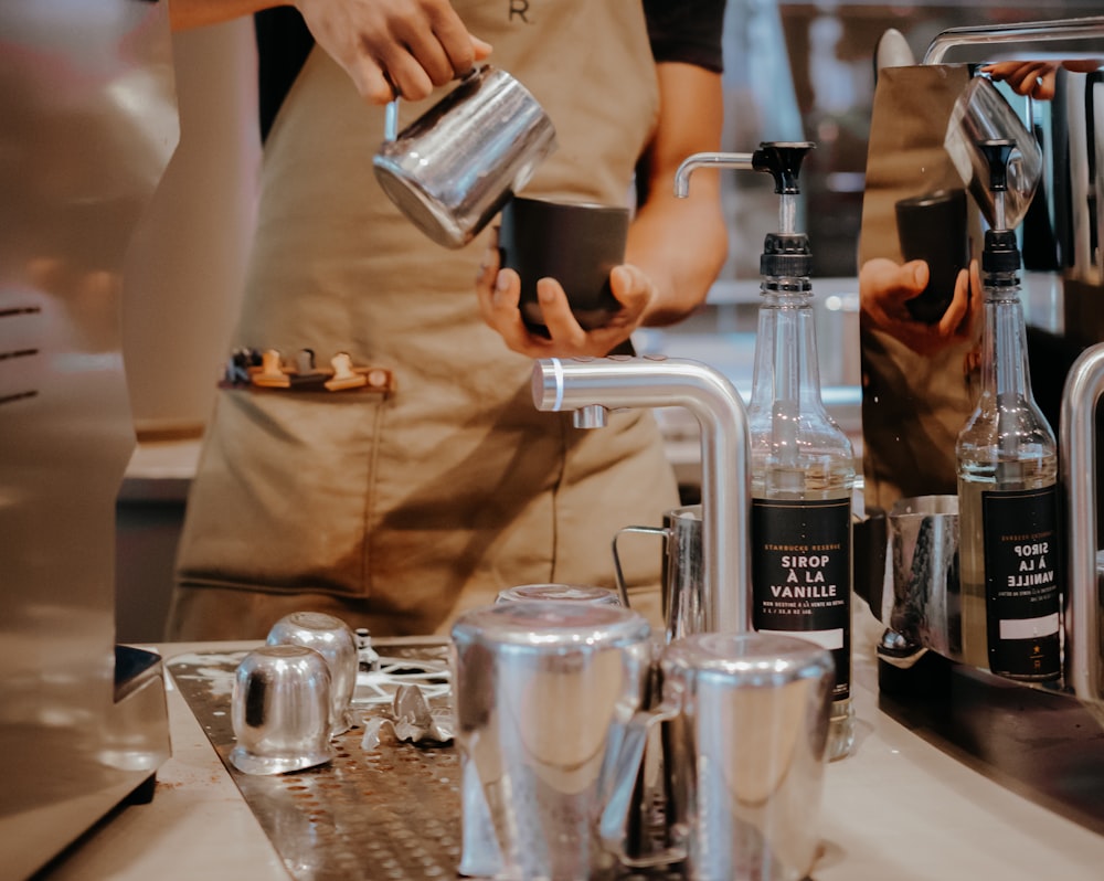 a person pouring a beverage into a cup