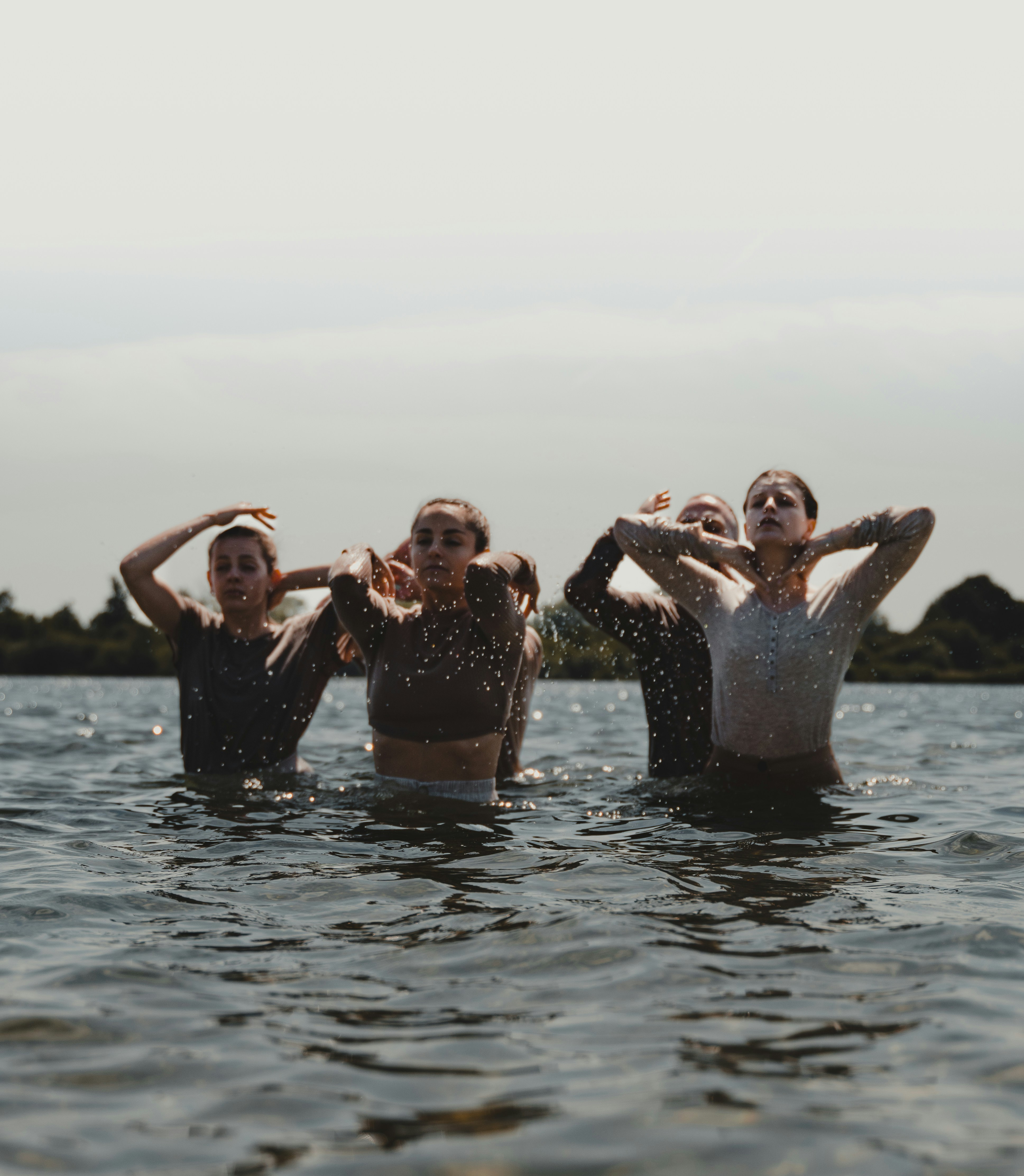 A group of women standing in a body of water photo – Free Grey Image on ...