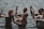 A group of people standing in water are engaged in a dance or meditative activity, with their eyes closed and hands raised in expressive gestures.