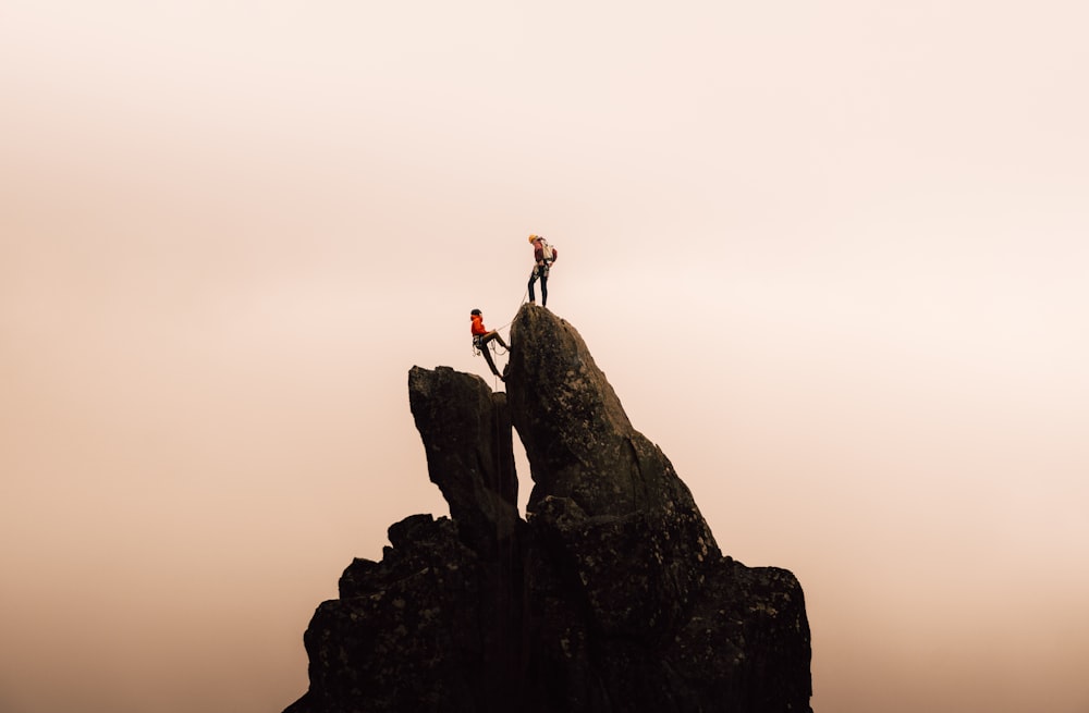 a couple of people standing on top of a mountain