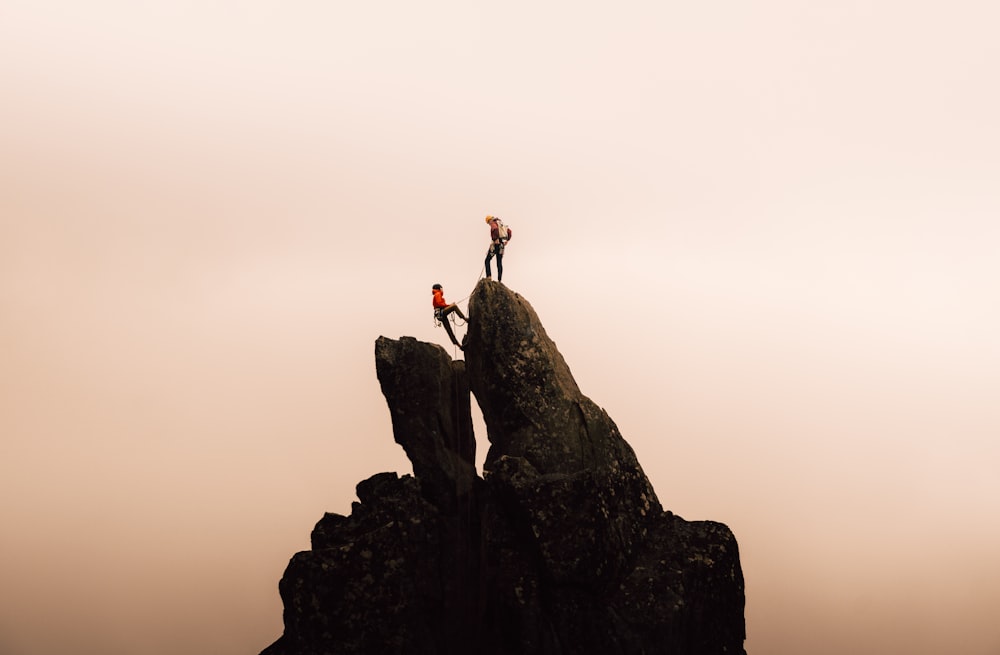 Un par de personas de pie en la cima de una montaña