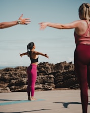 two women doing yoga on the beach