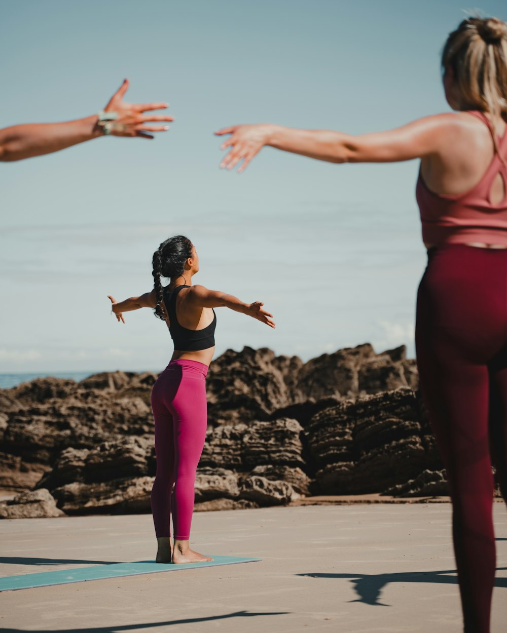 two women doing yoga on the beach