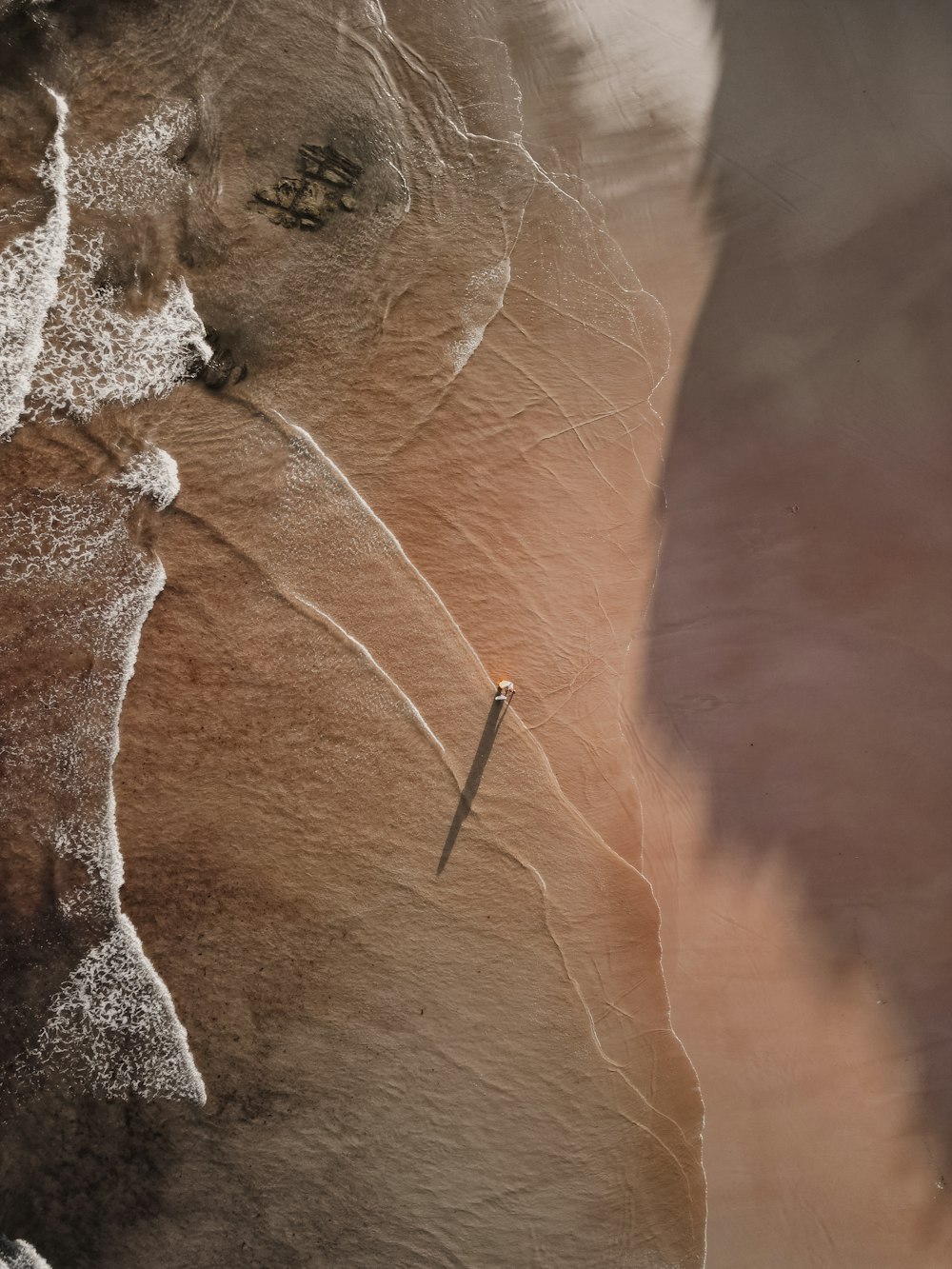 an aerial view of a rock formation with a knife sticking out of it