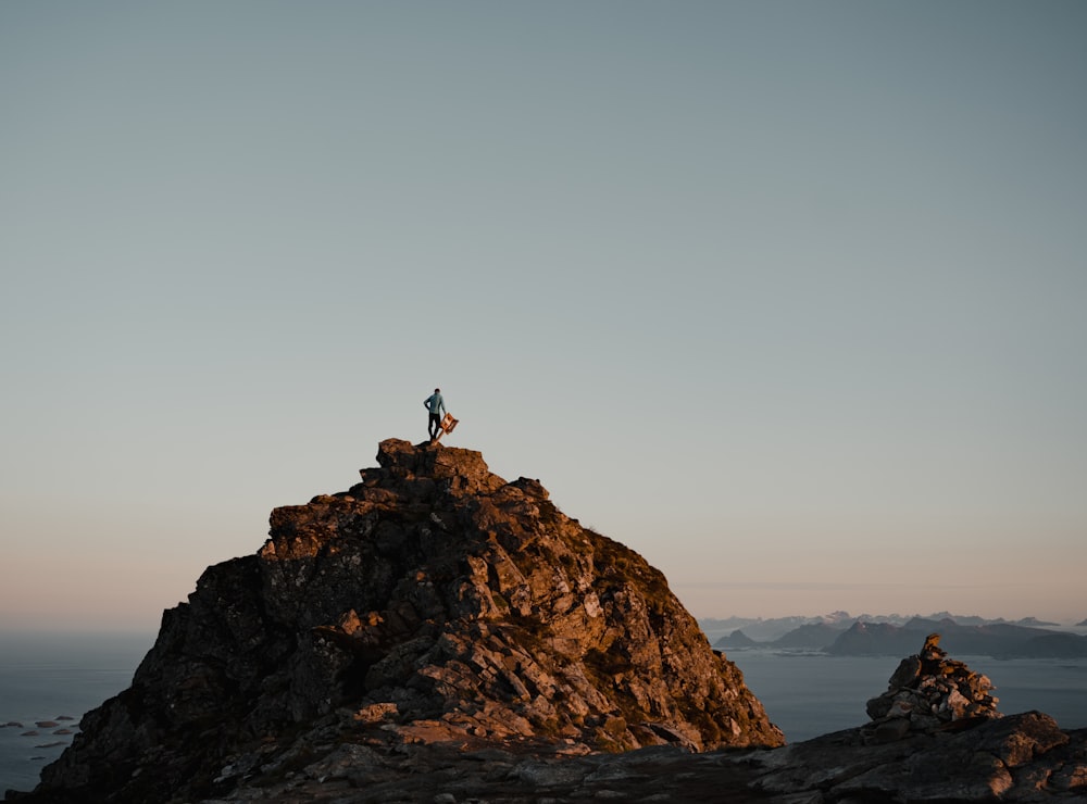 a person standing on top of a large rock