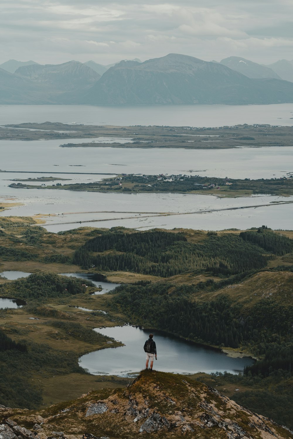 una persona de pie en la cima de una colina con vistas a un lago