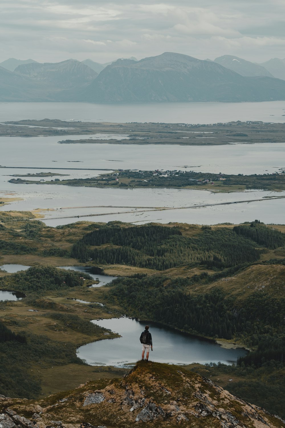 a person standing on top of a hill overlooking a lake