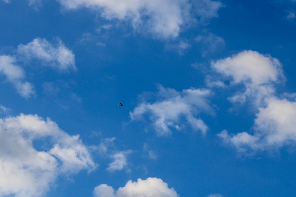 a plane flying through a cloudy blue sky