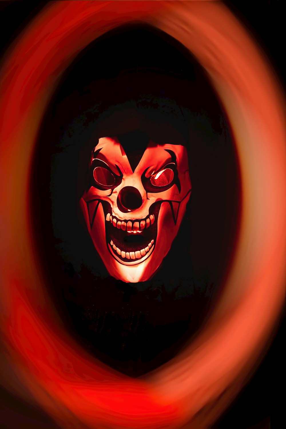 a scary clown mask is seen through a circular object