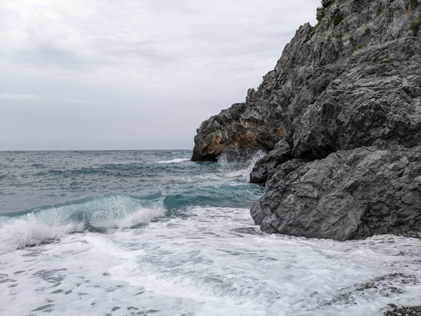 A quiet moment at the seaside cliffs of Cornwall, waves crashing against rugged rocks.