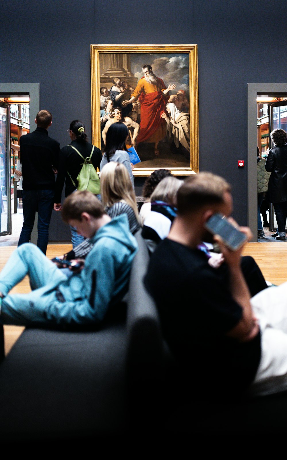 a group of people looking at a painting in a museum