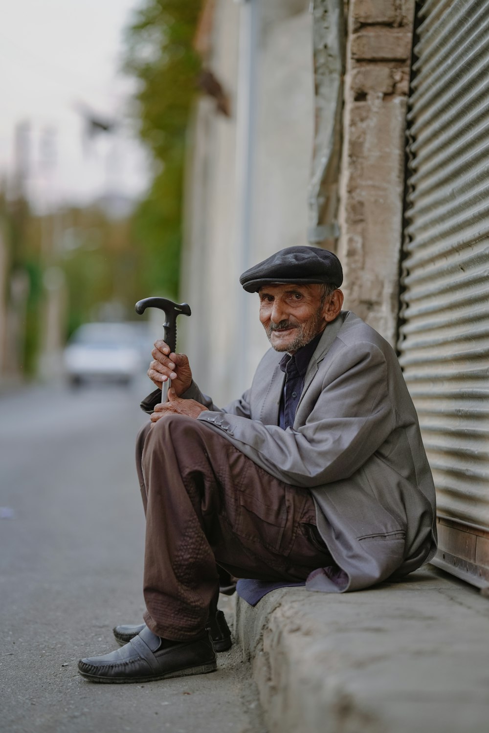 a man sitting on the side of a building holding an umbrella