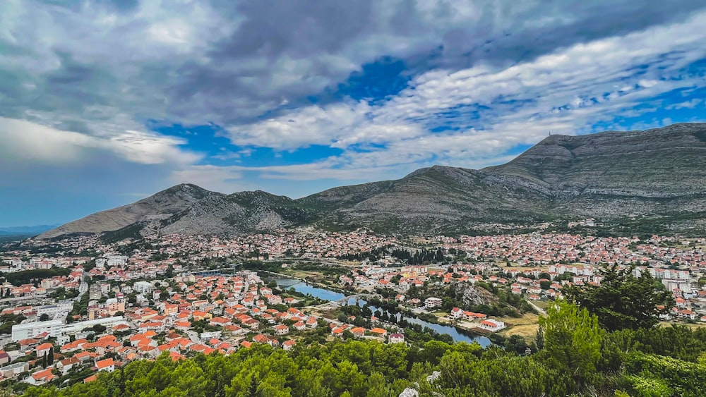 a scenic view of a city with mountains in the background