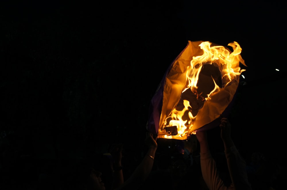 a group of people holding up a fireball in the dark