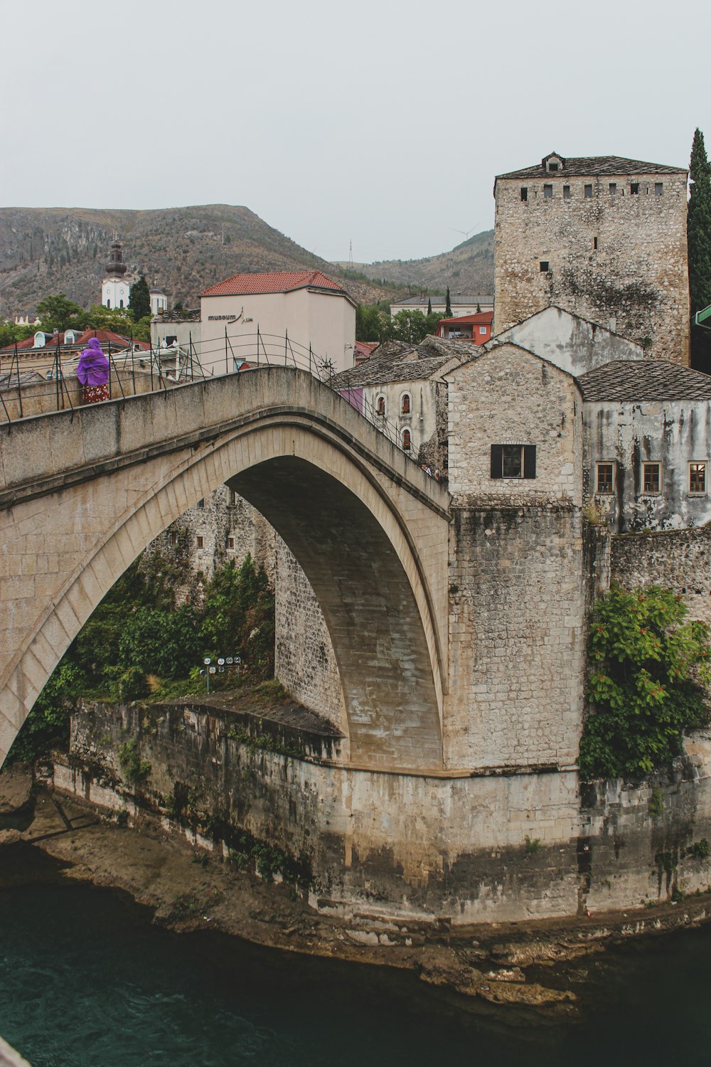 a bridge over a body of water with buildings in the background