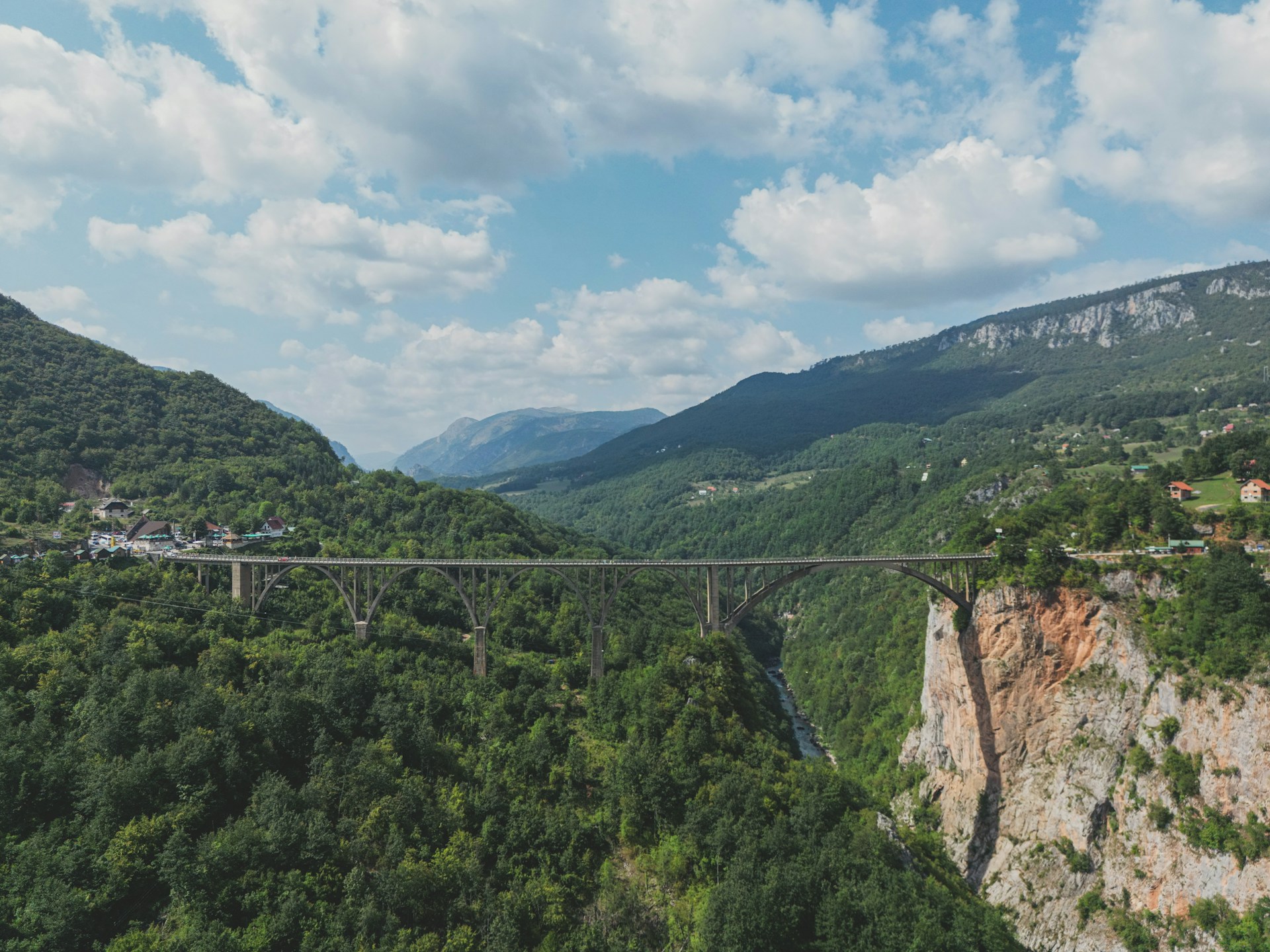 a bridge over a river surrounded by mountains