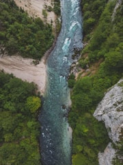 Aerial view of a green forested area with a river flowing through.