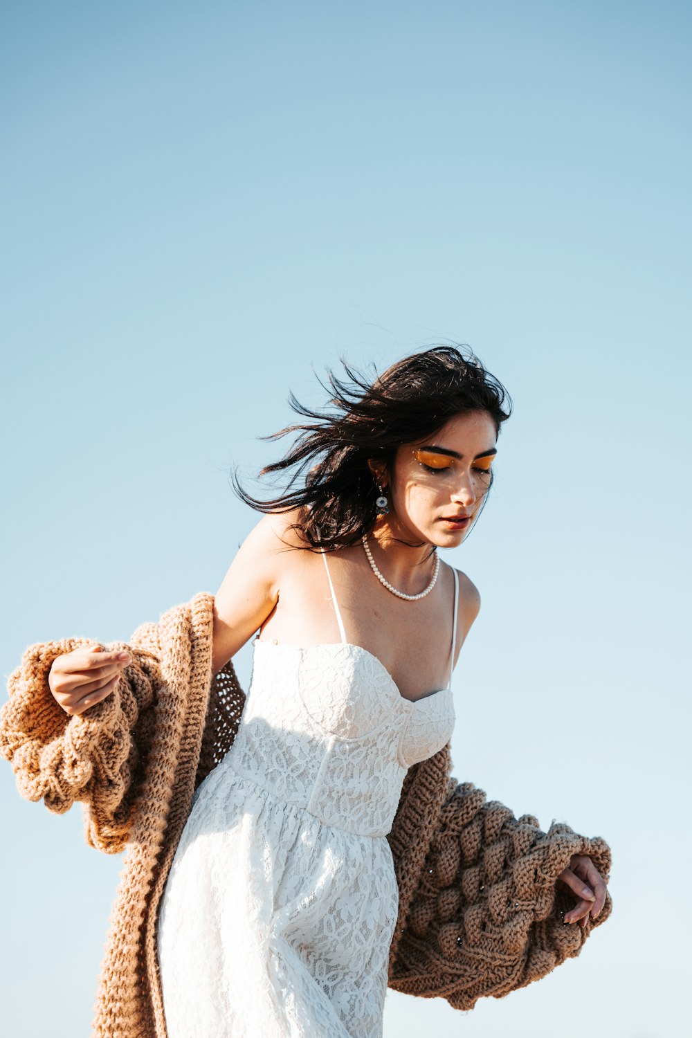 a woman in a white dress is holding a jacket