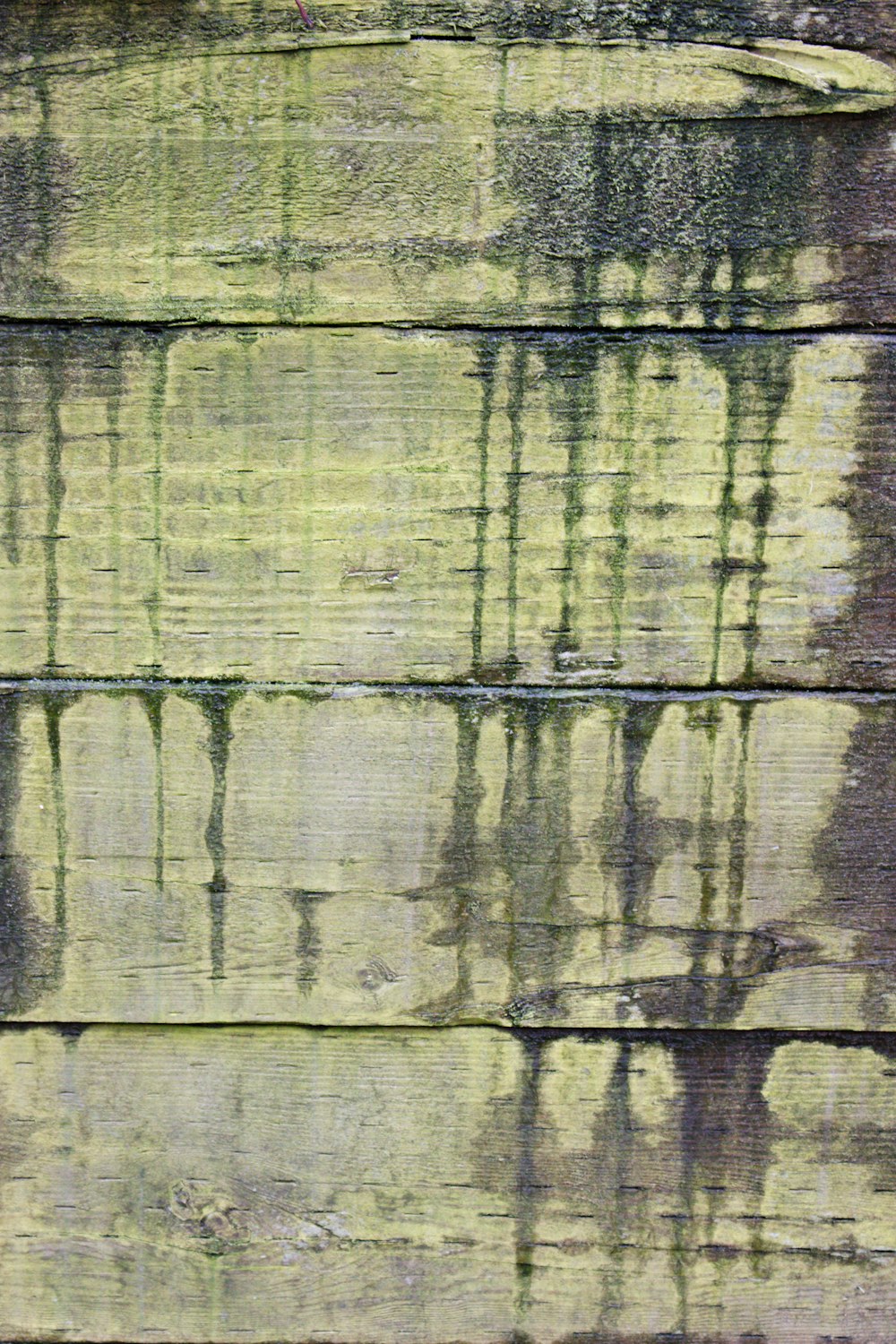 a close up of a wooden wall with green paint