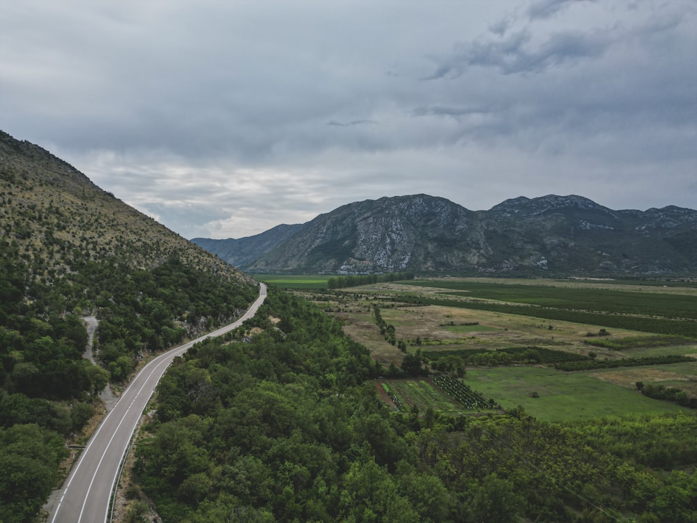 a road winding through a lush green valley