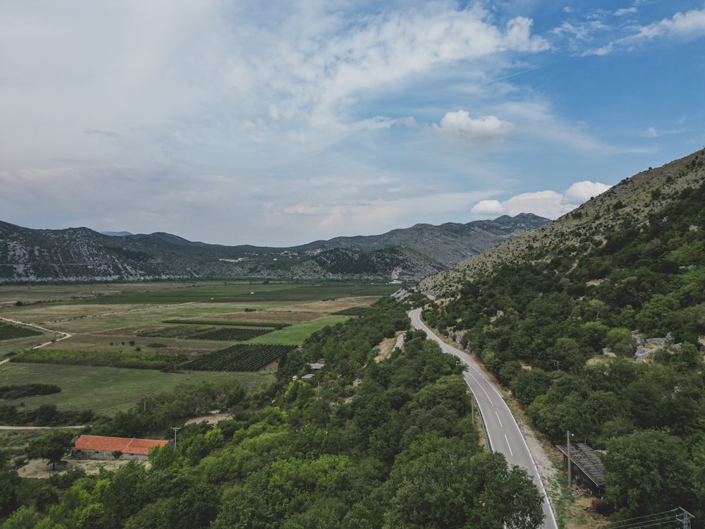 a winding road in the middle of a lush green valley