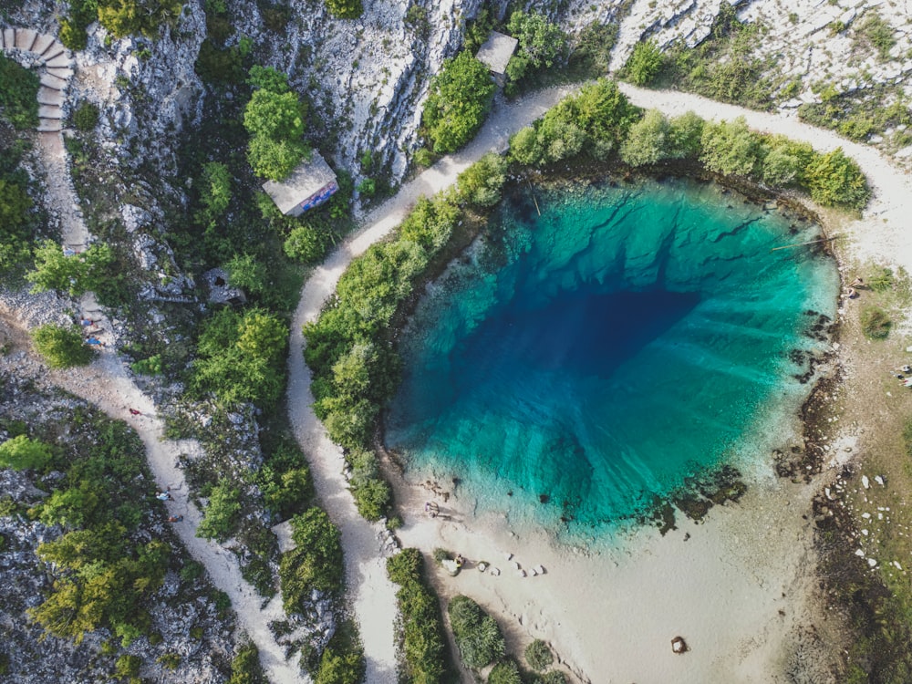 an aerial view of a blue lake surrounded by trees