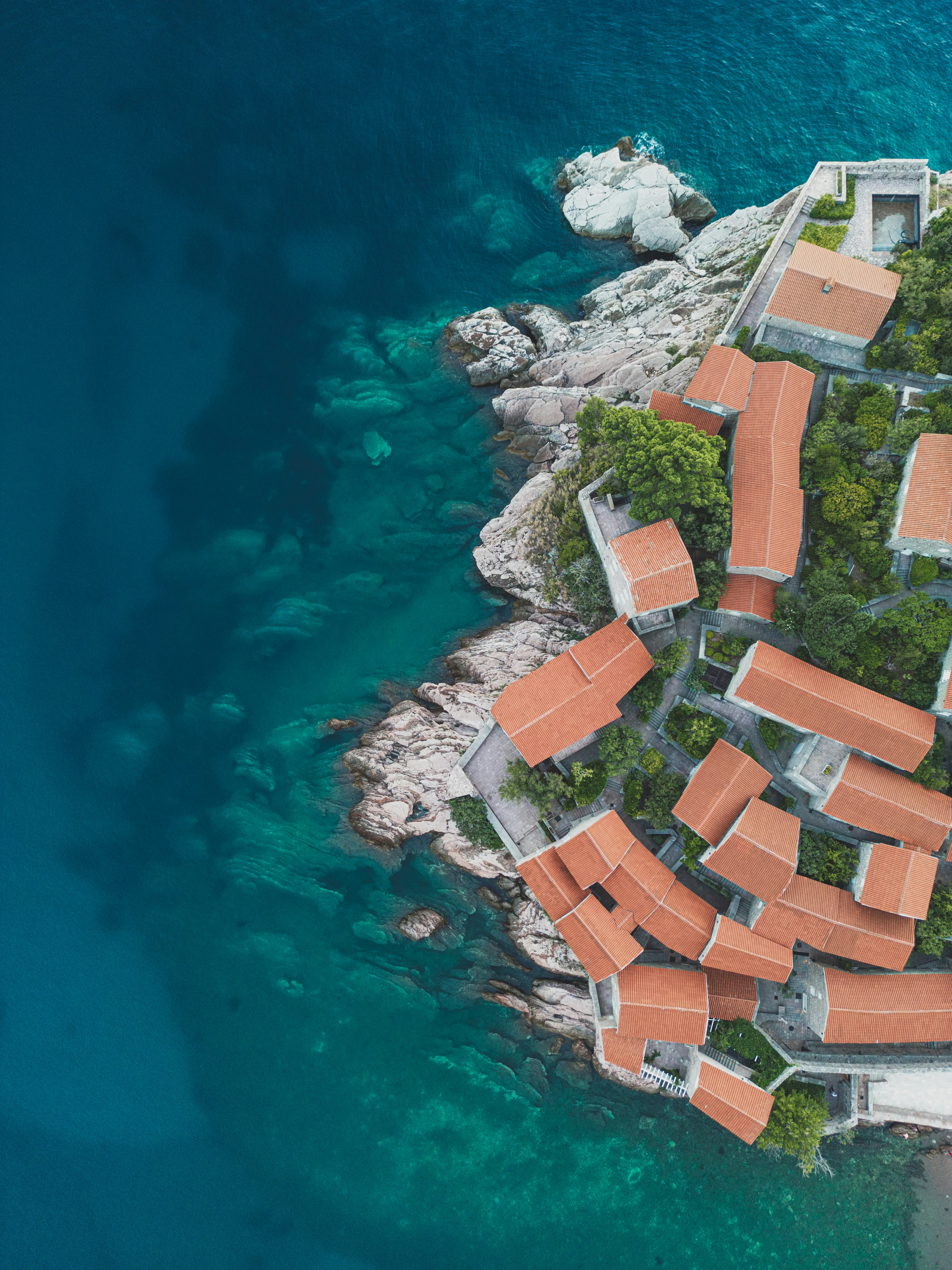 an aerial view of a small island with red roofed houses