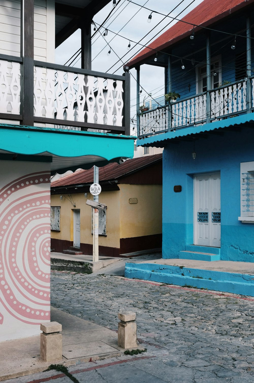 a blue building with a white balcony next to a blue building