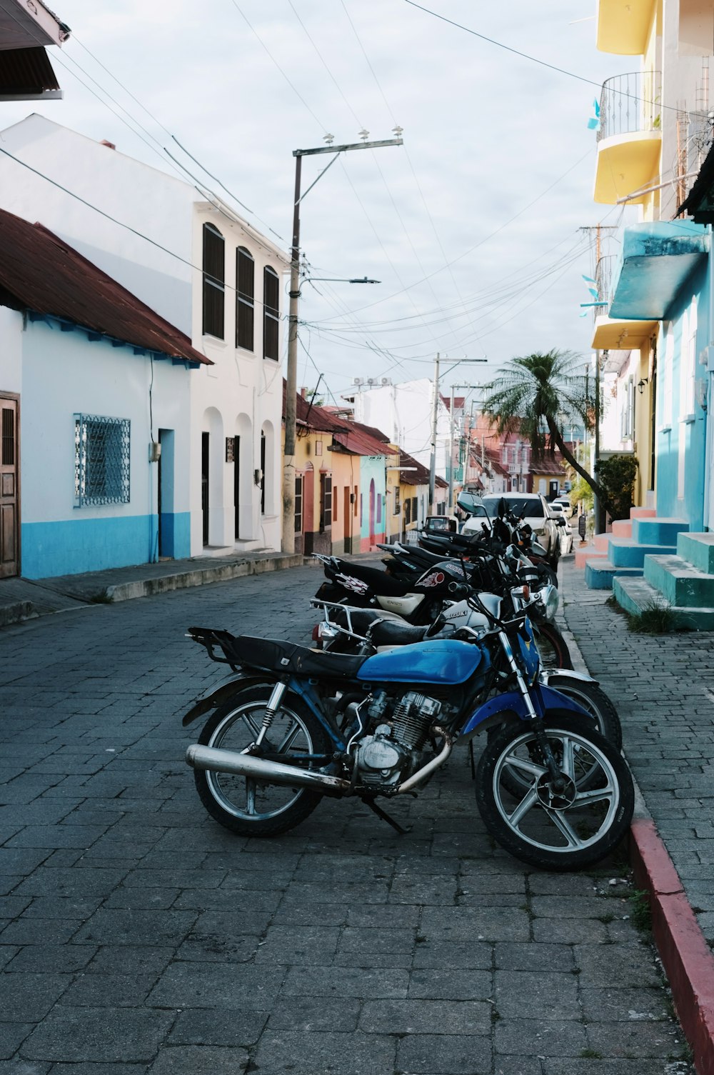 a row of motorcycles parked on the side of a street