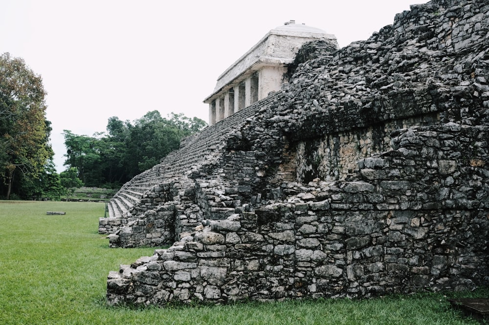 a large stone structure sitting on top of a lush green field