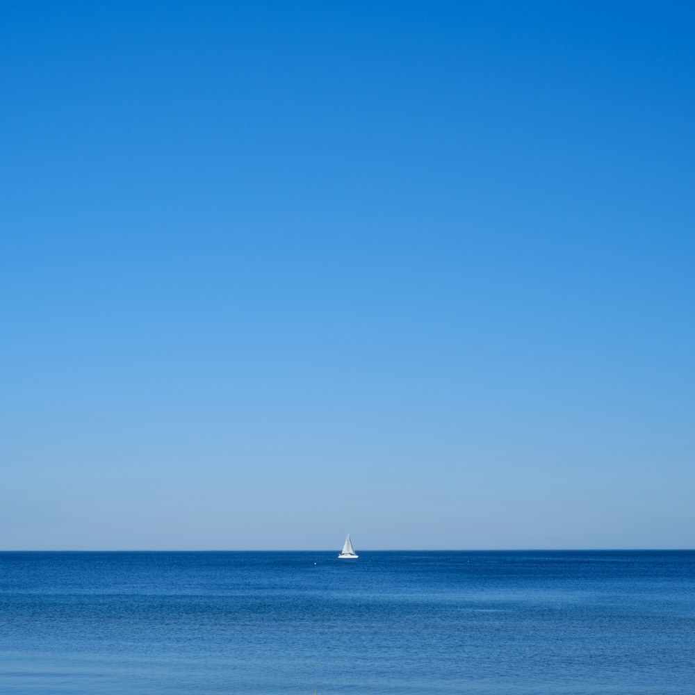a sailboat in the ocean on a clear day