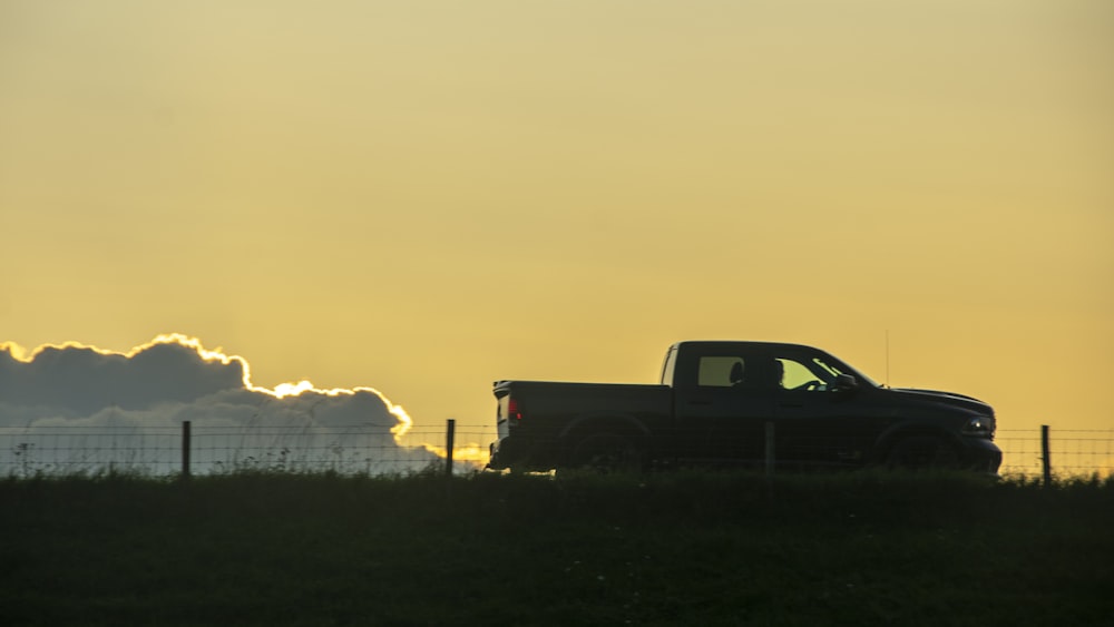 a truck is parked in a field at sunset